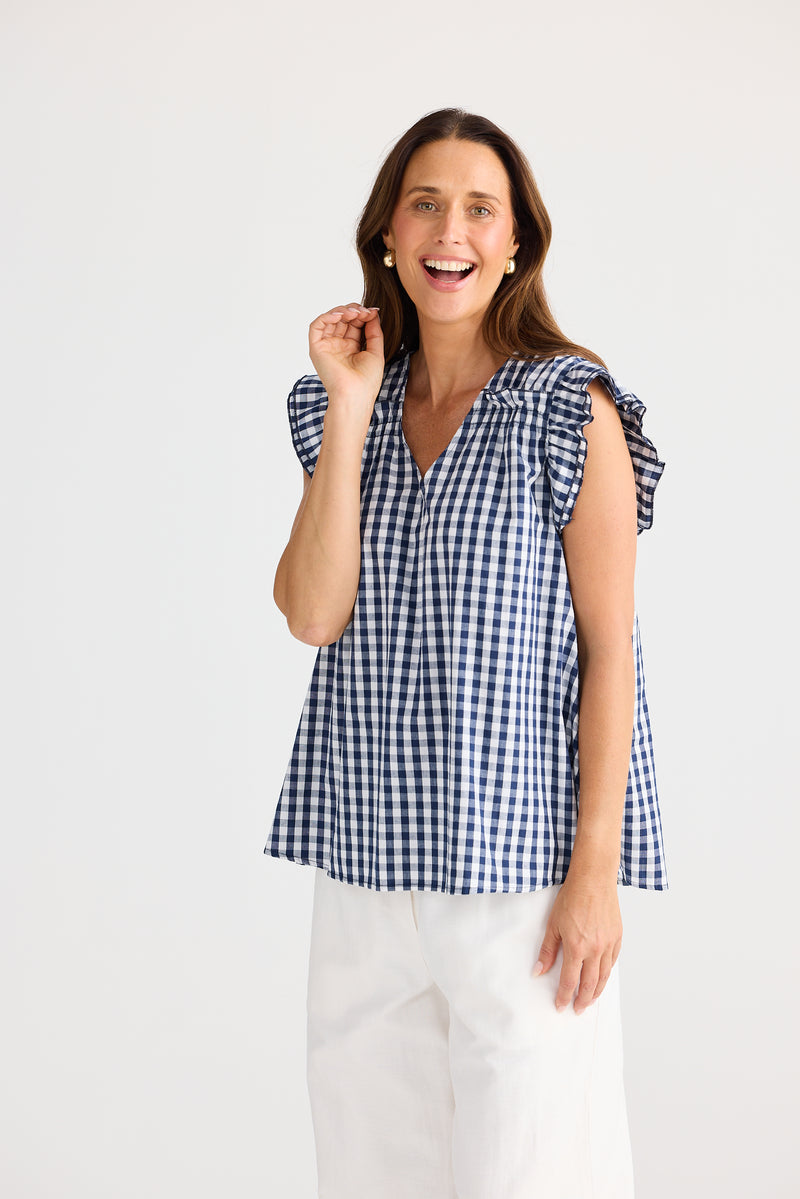 Woman wearing a blue and white checkered blouse against a white background
