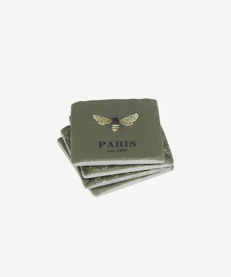 Set of four green bee coasters with bee design and 'PARIS' text on a white background