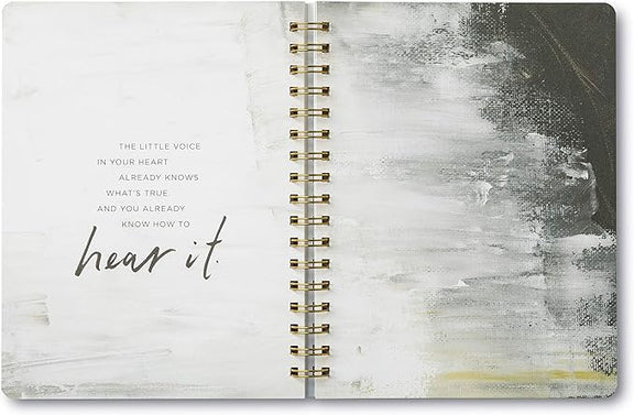 Open notebook with abstract design and inspirational quote on a white background