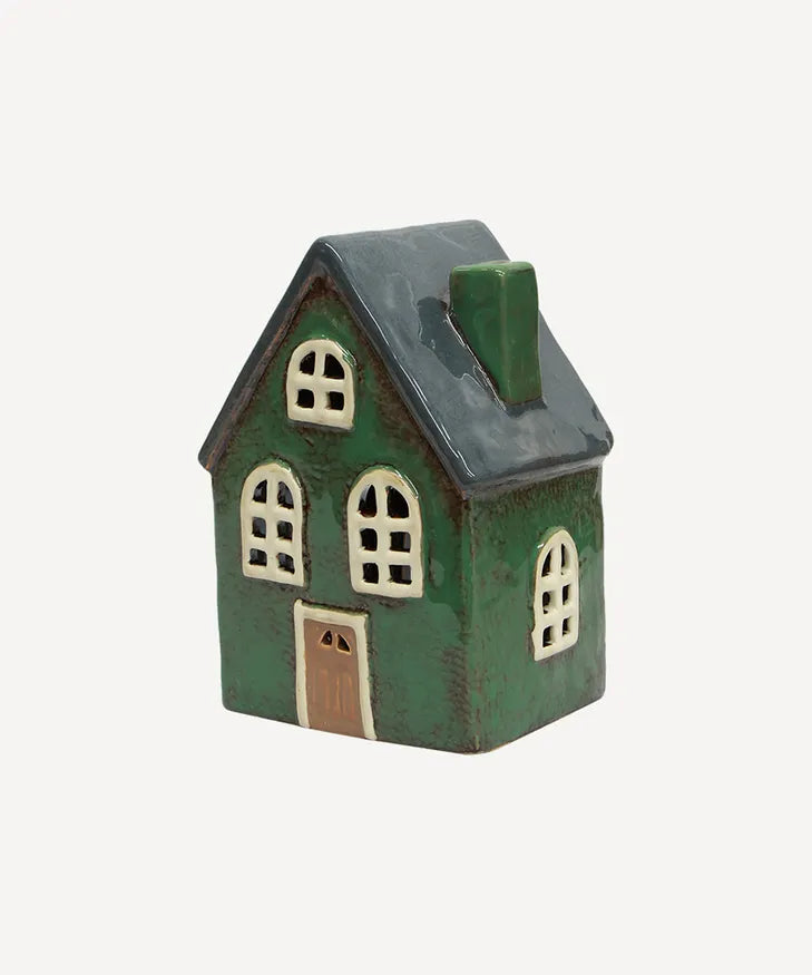 Ceramic tealight barn glowing with candle inside – holiday display