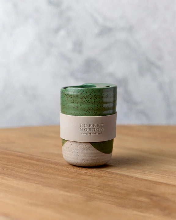 Green reusable travel mug with silicone wrap from The Wanderer Collection.