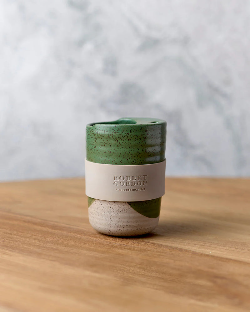 Green reusable travel mug with silicone wrap from The Wanderer Collection.