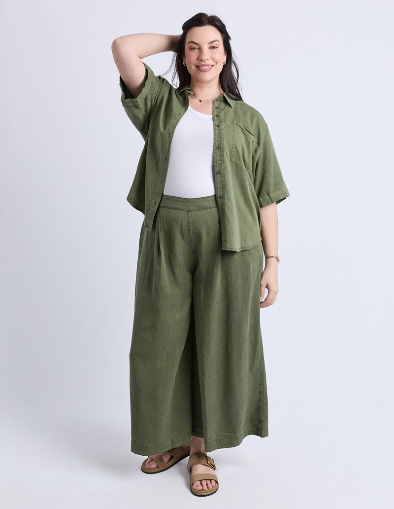 Woman wearing a green outfit with a white background
