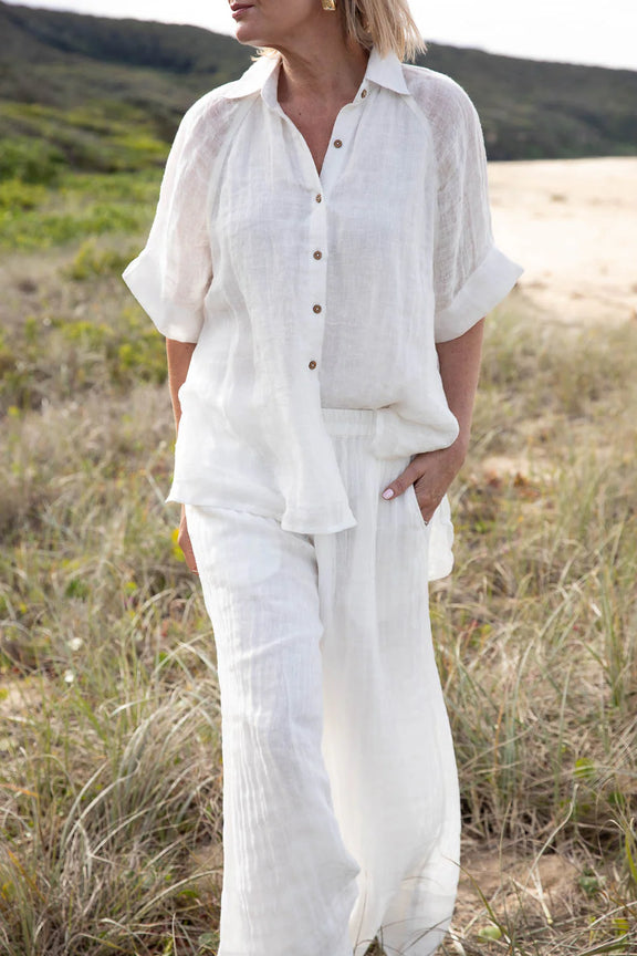 Person wearing a white outfit standing in a natural setting