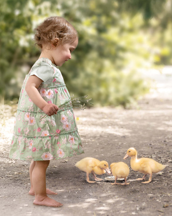 Baby wearing Toshi Matilda Desert Rose Apple dress in soft green floral design.
