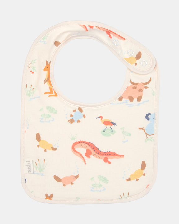 Toshi Baby Bib Down Under Kakadu Dawn flat-lay showing front cotton print and press studs.