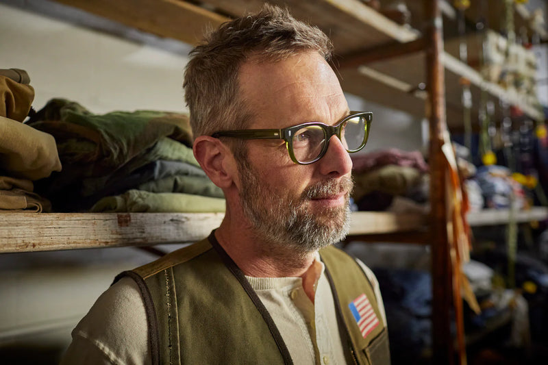 Man wearing stylish green reading glasses 