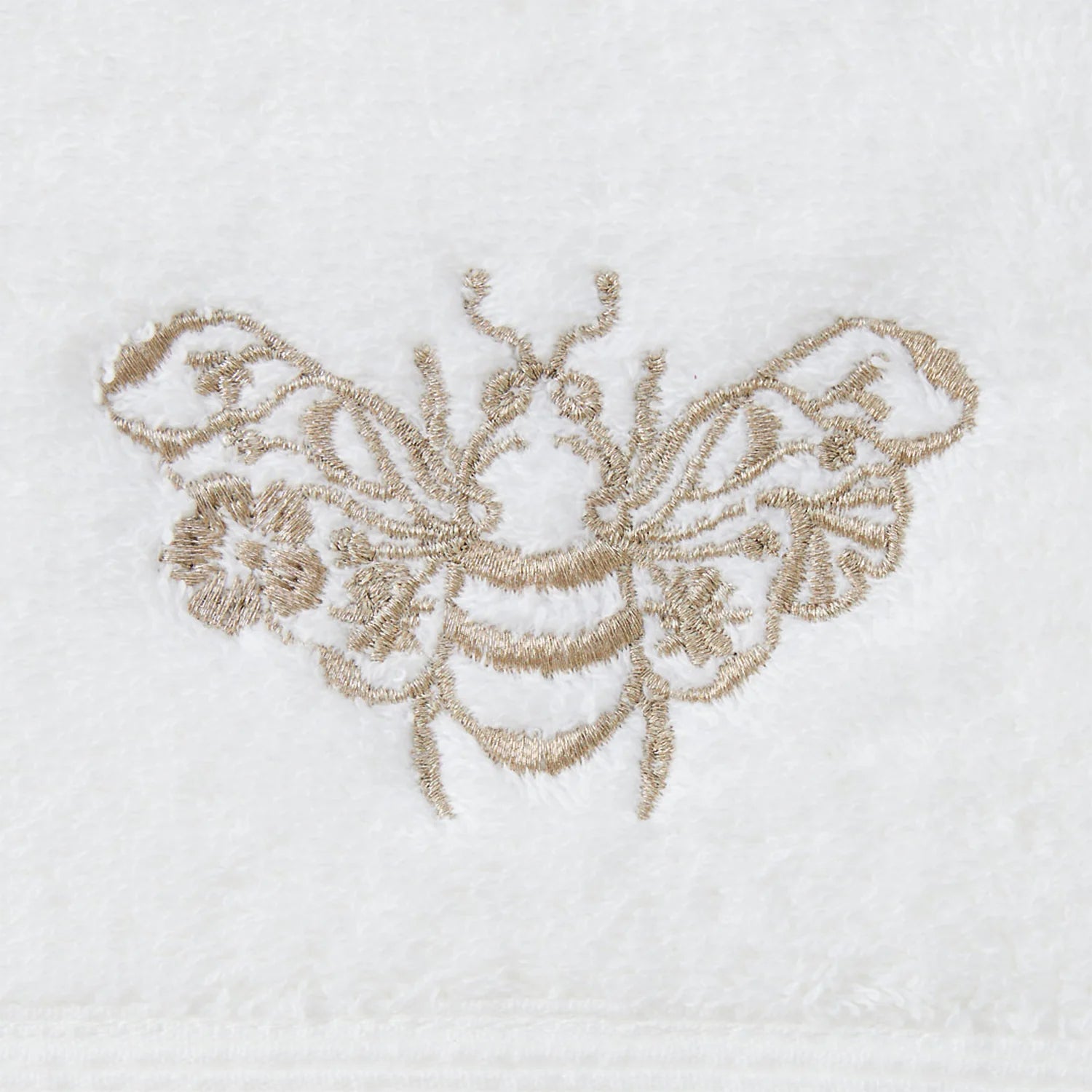 Close-up of gold embroidered motif on Beebee Hand Towel.