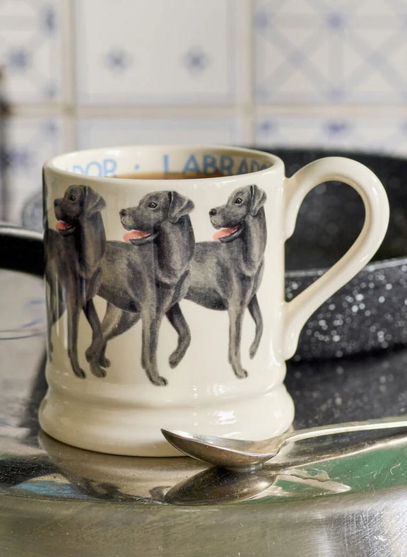 White earthenware mug featuring a Black Labrador design and classic Emma Bridgewater half pint shape.