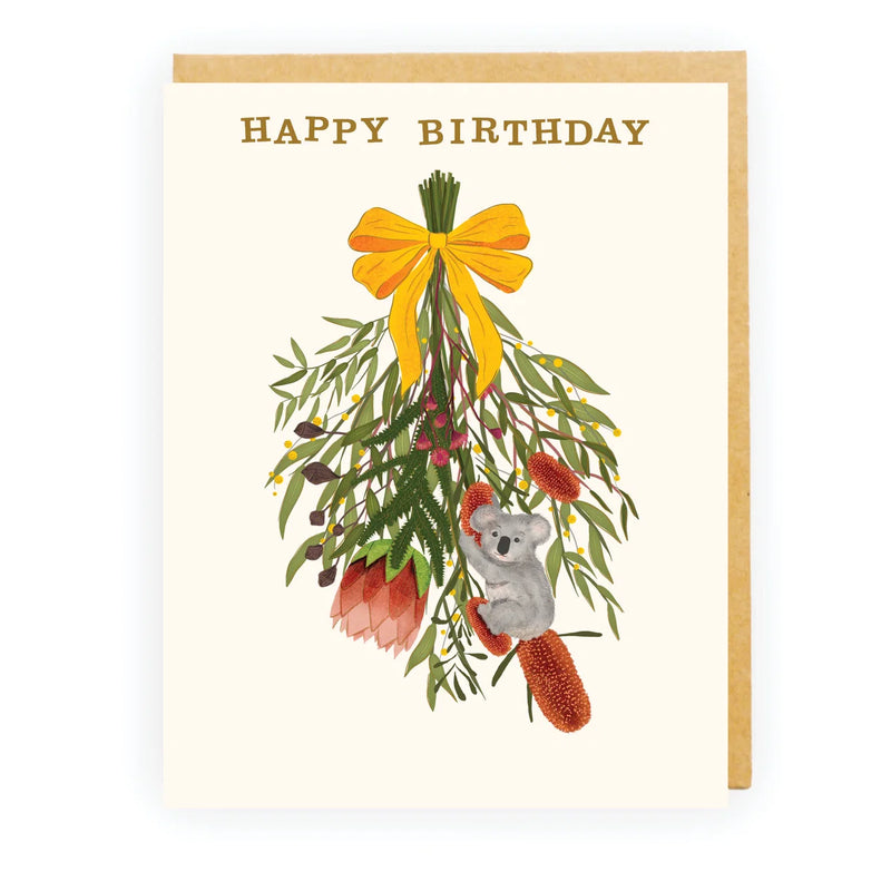 Happy Birthday card featuring a koala with Australian native flowers and yellow ribbon