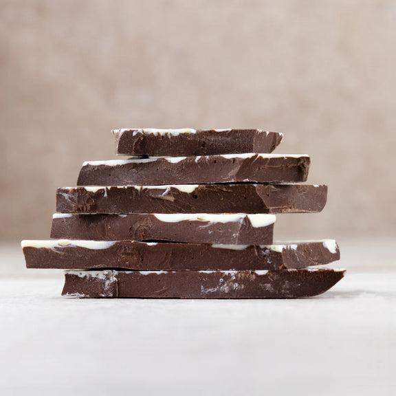 Stack of dark chocolate bars on a neutral background