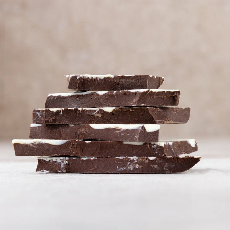 Stack of dark chocolate bars on a neutral background