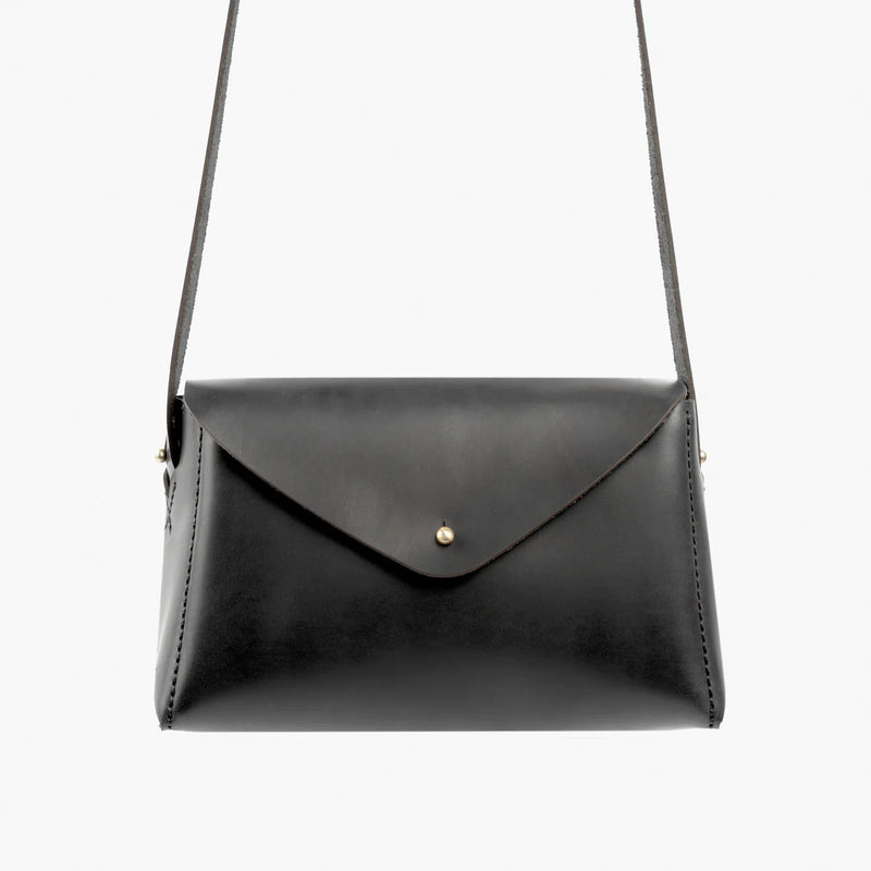 Black leather handbag with a strap on a white background by Dorothy Mini Black Loyal Workshop