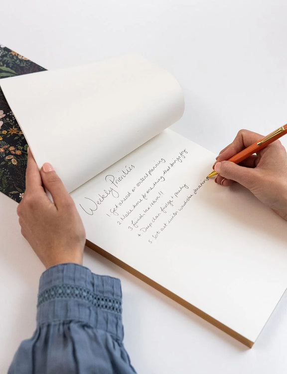 Premium Dusk in Bloom desk jotter with gold foil belly band and floral artwork.