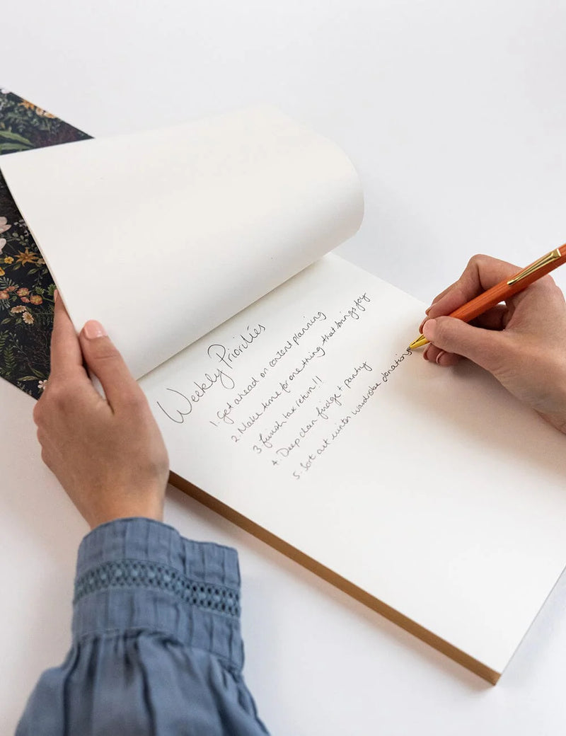 Premium Dusk in Bloom desk jotter with gold foil belly band and floral artwork.