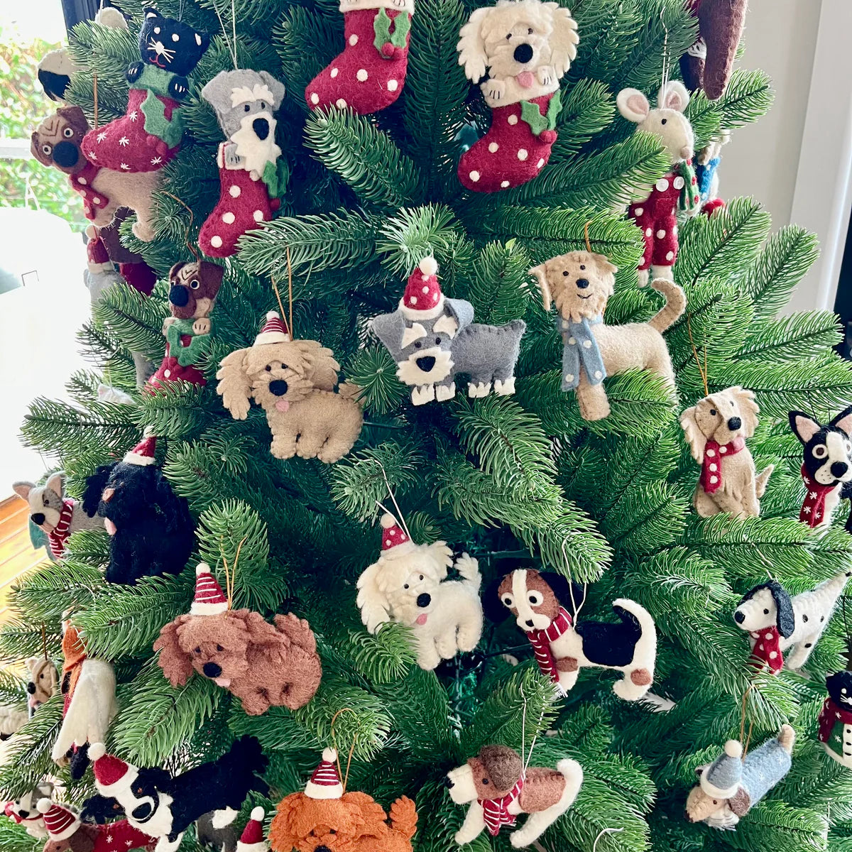 Fair-trade wool felt French Bulldog holiday decoration with other dog decorations on tree.