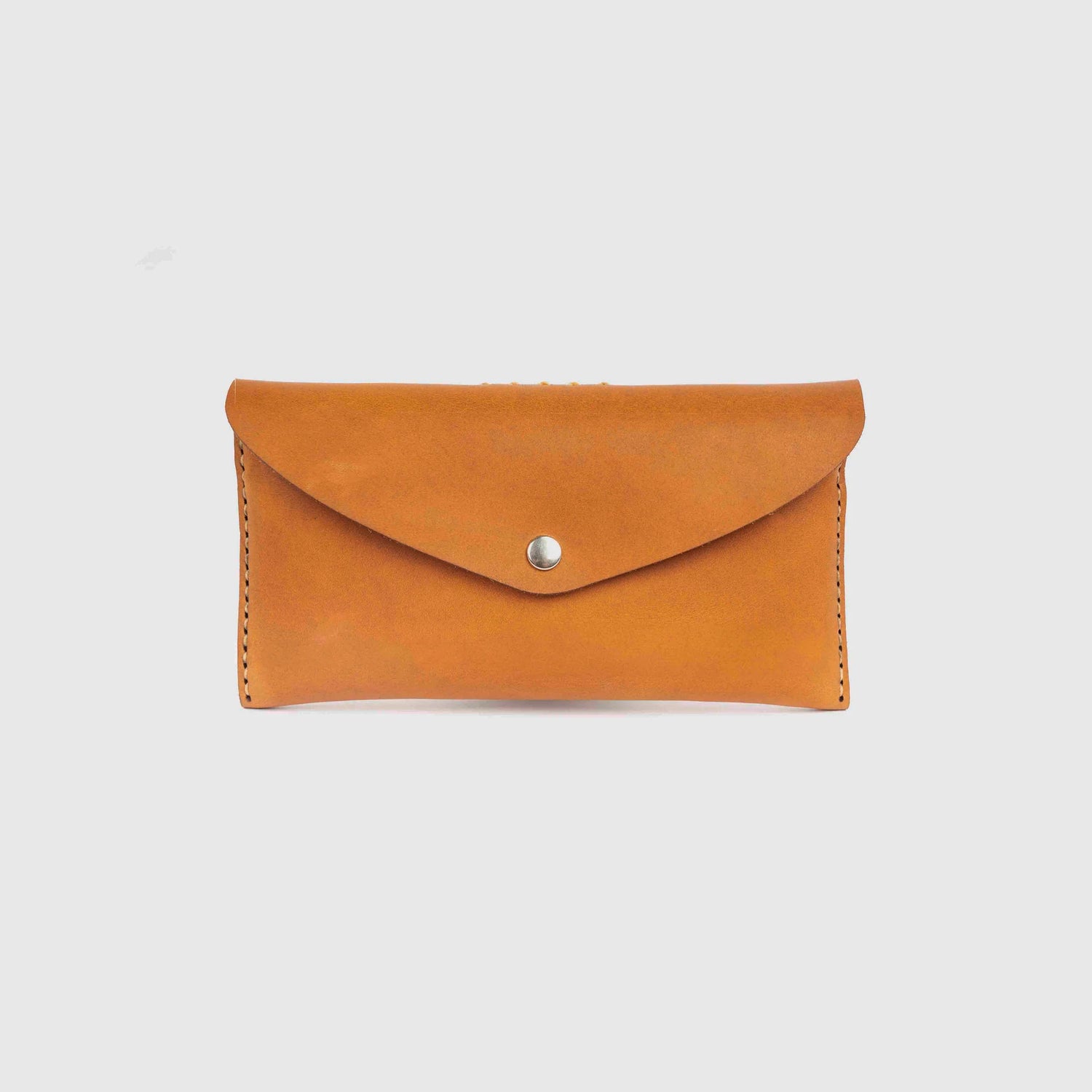 Brown leather wallet with a silver button on a light gray background