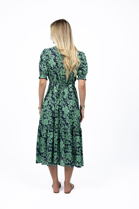 Woman wearing a green floral dress on a white background