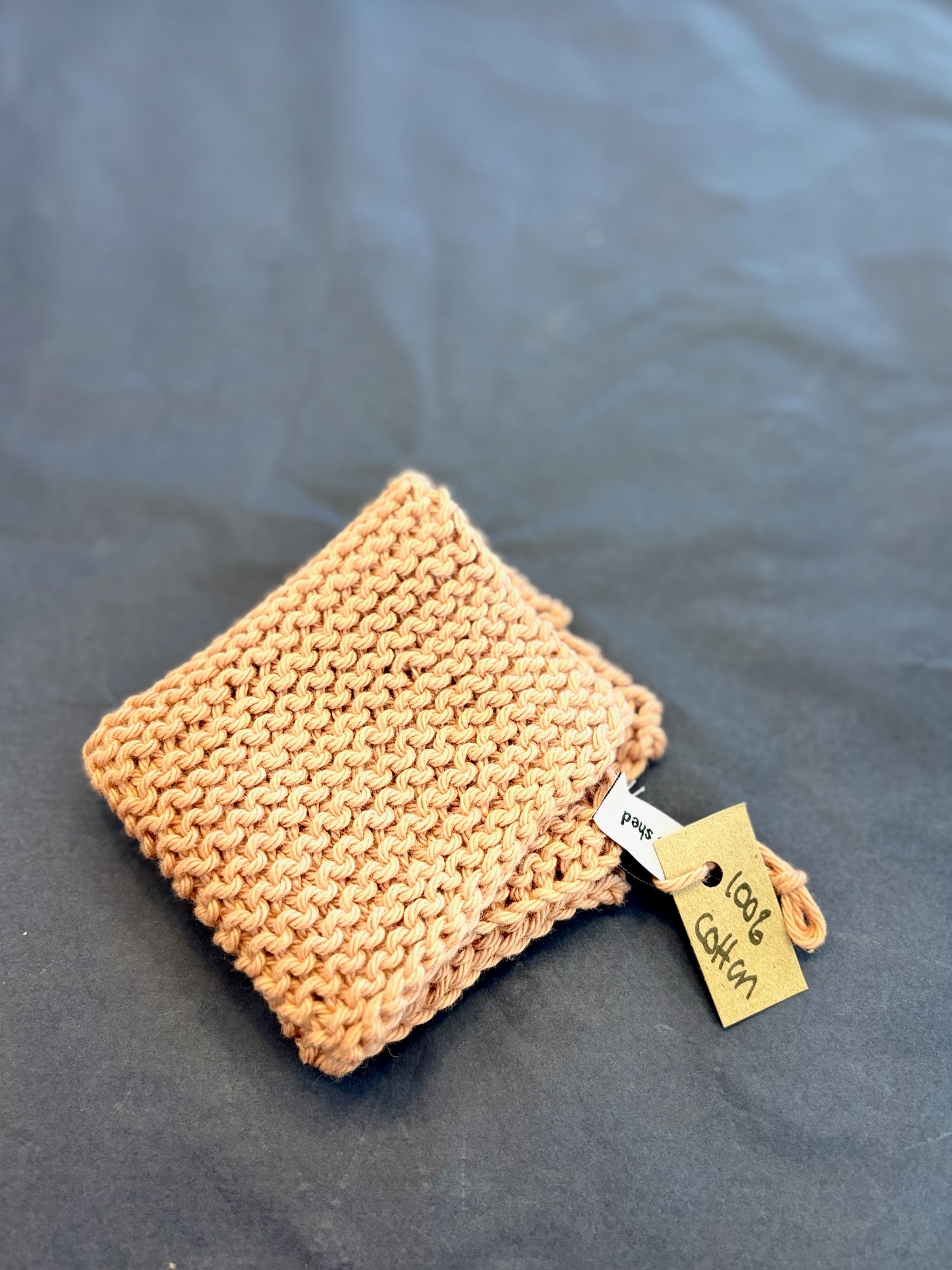 Knitted rose pink coloured cotton face washer.