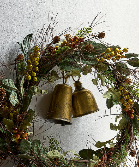 Gold iron bell hanging on a Christmas wreath