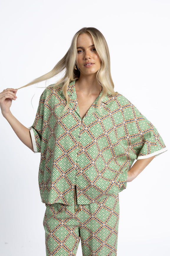 Woman wearing a green patterned outfit on a white background