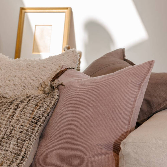 50x50cm pink corduroy cushion with leather tassel detail for sofa, armchair or bedroom styling.