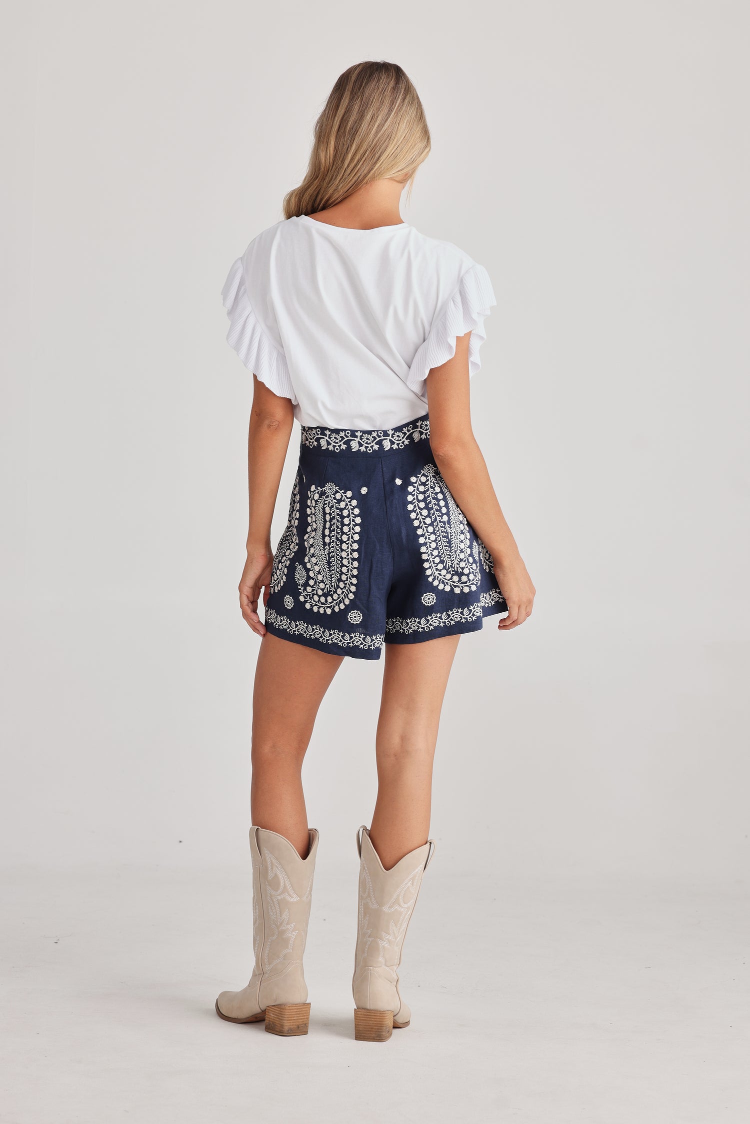 Women’s navy linen shorts with contrast embroidery, true waist fit - view from behind.