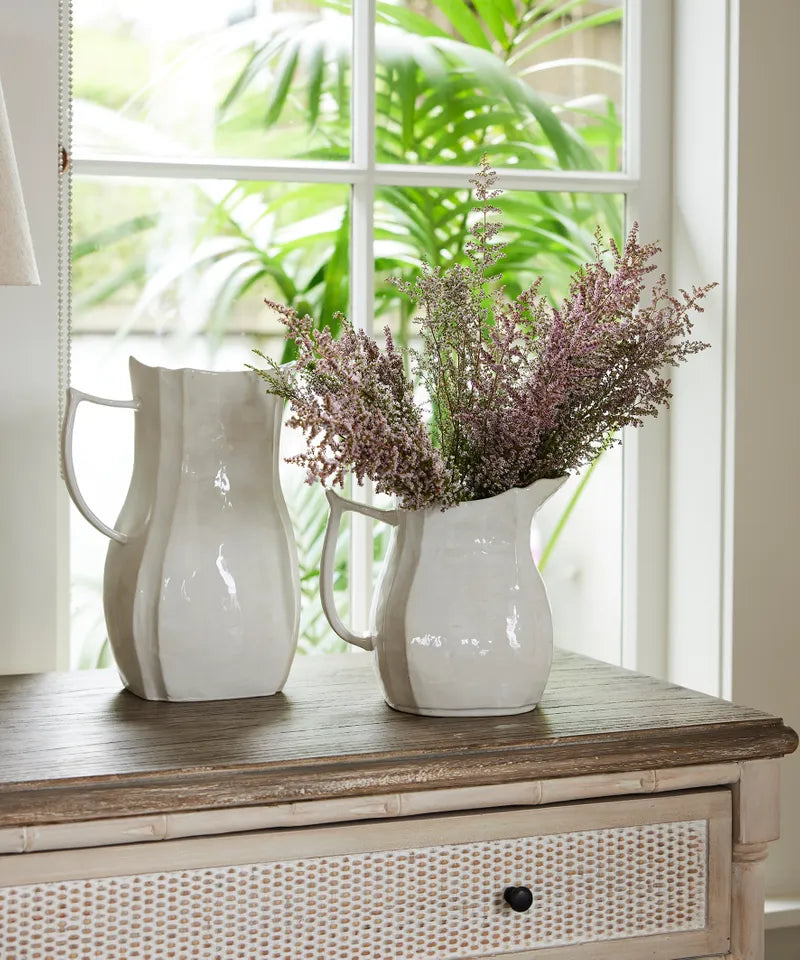 Jolie Jug Small in off-white stoneware on table holding flowers next to Jolie Jug Large.