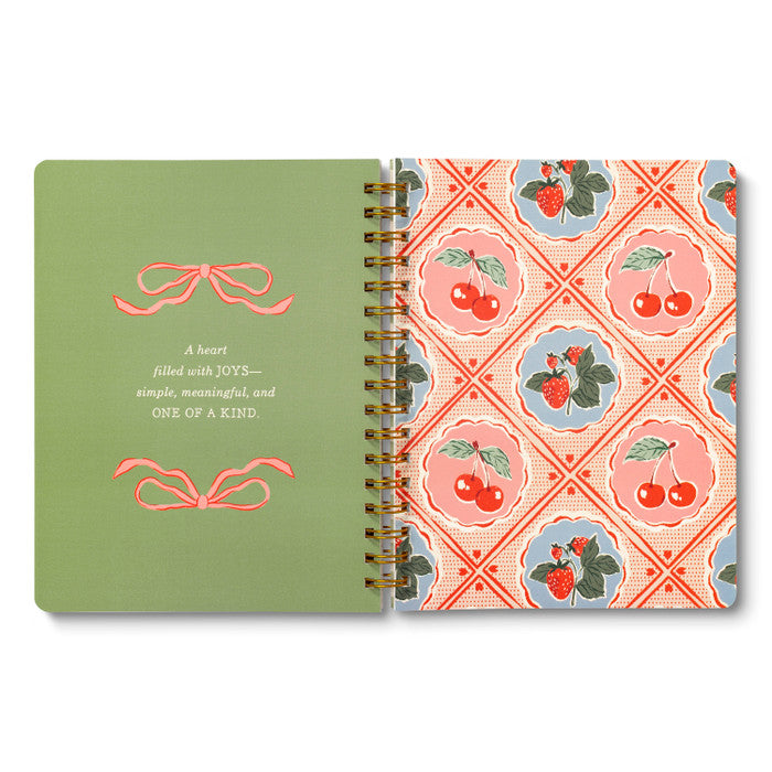 Notebook with green cover and cherry pattern on white background