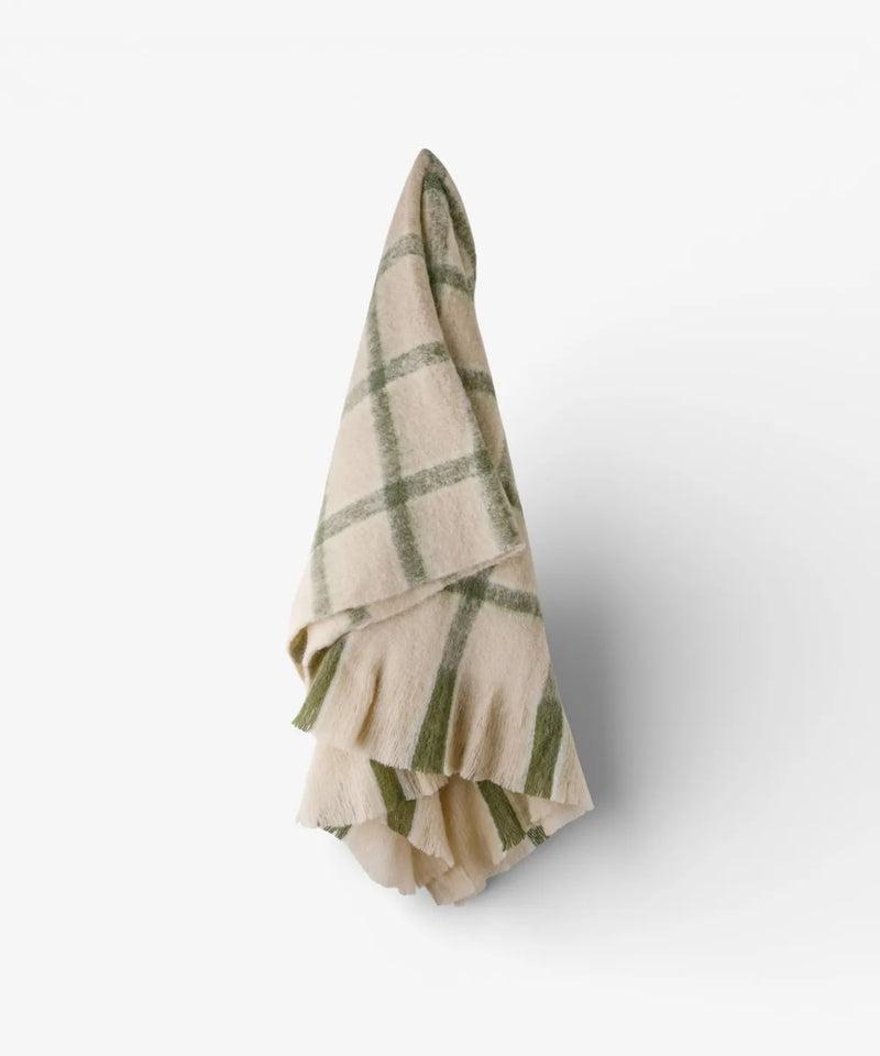 Classic green check throw with neutral background and decorative fringe.