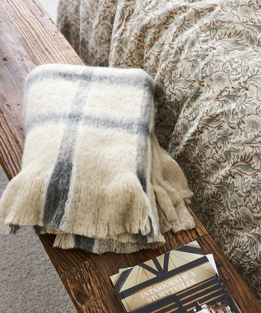 Grey and neutral checked throw measuring 125x150cm with fringed edges.