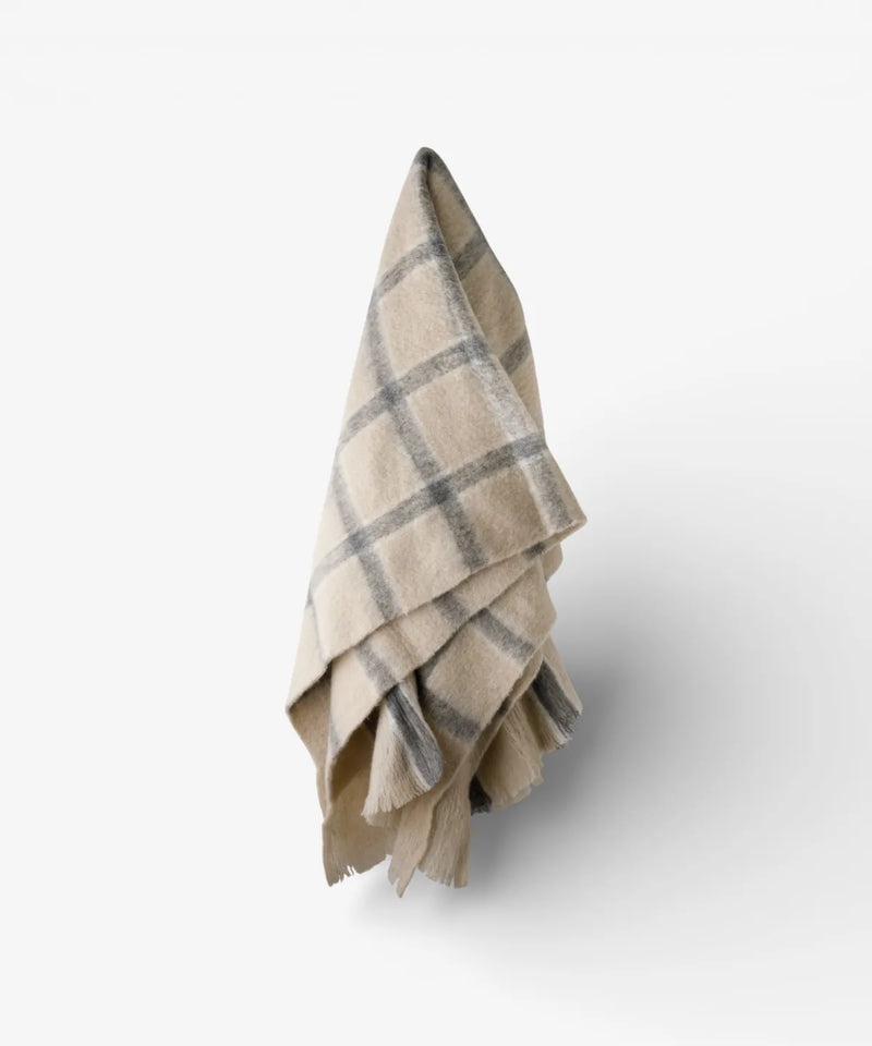 Classic grey check throw with neutral background and decorative fringe.