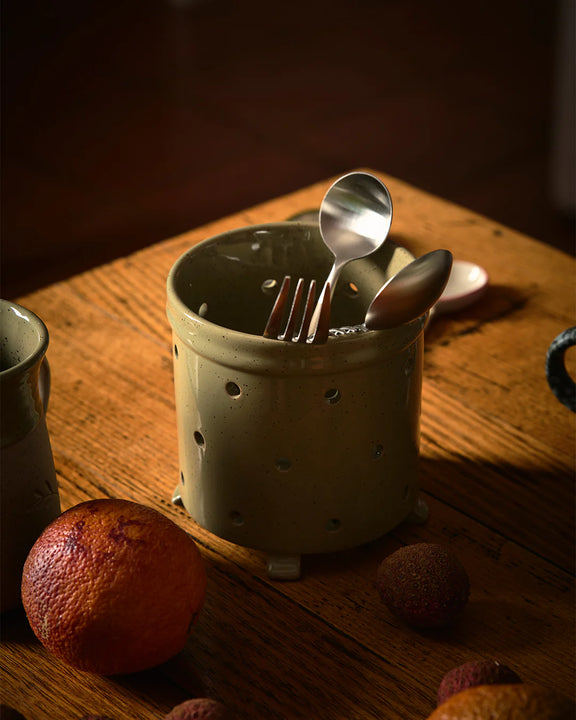 Stoneware utensil holder with cutlery on a wooden surface with fruits. Peppercorn stoneware cutlery drainer 12cm
