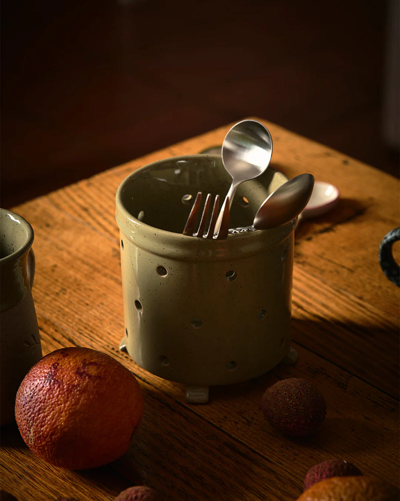 Stoneware utensil holder with cutlery on a wooden surface with fruits. Peppercorn stoneware cutlery drainer 12cm