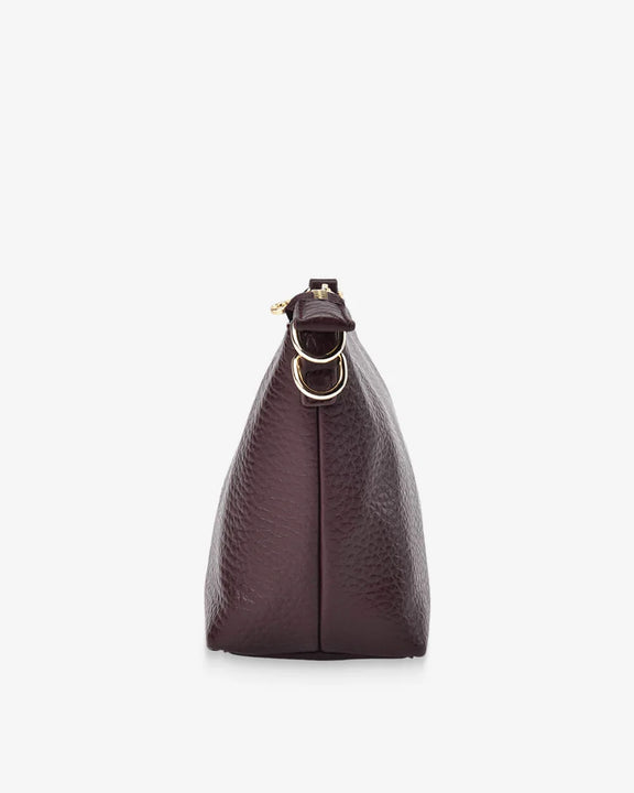 Wine leather handbag with gold chain on a white background