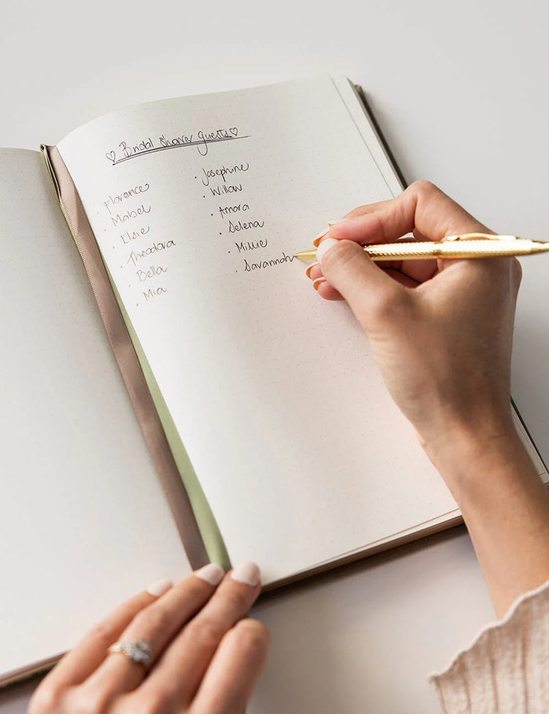 Linen bound bullet journal with gold page edges for planning, journalling and note taking.