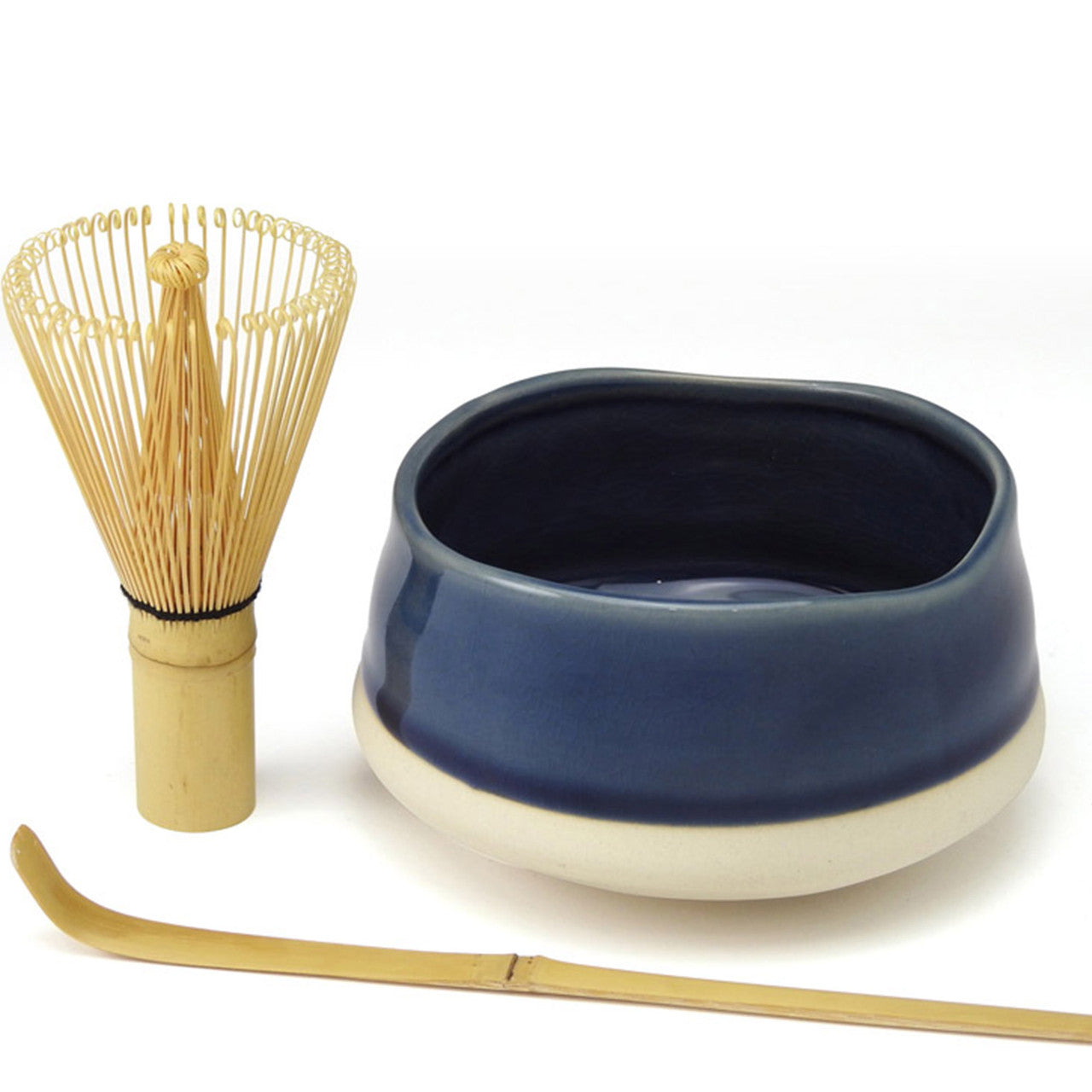 Blue ceramic bowl with bamboo whisk and scoop on a white background