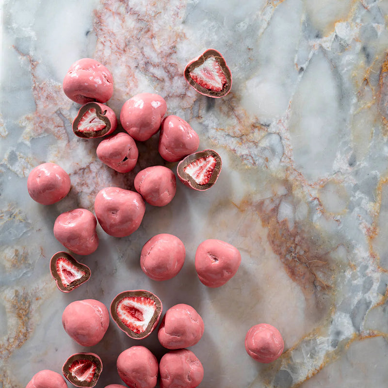 Pink chocolate-covered strawberries on a marble surface 