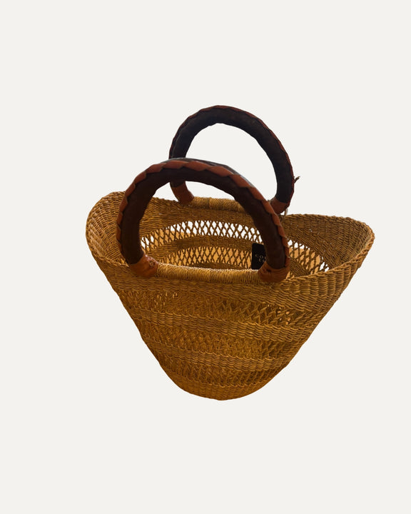 Handmade African mini shopper basket in natural elephant grass with tan or black leather handle.
