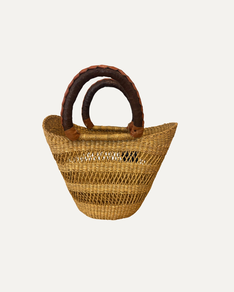 Hand-woven mini market basket from Ghana featuring natural elephant grass and leather handles.