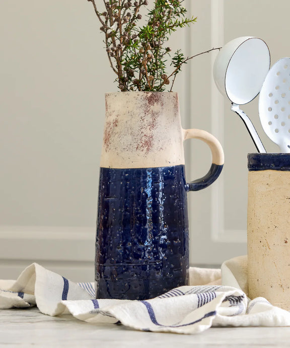 Dark blue glazed terracotta jug styled on kitchen bench