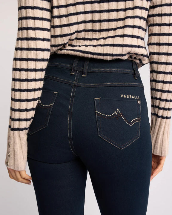 Rear view of women's full-length stretch denim jeans in indigo blue.