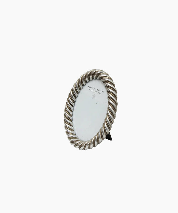 Decorative oval mirror with twisted metal frame on a white background