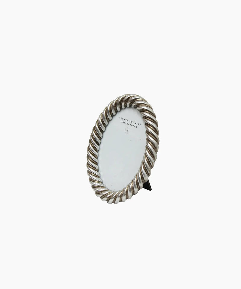 Decorative oval mirror with twisted metal frame on a white background