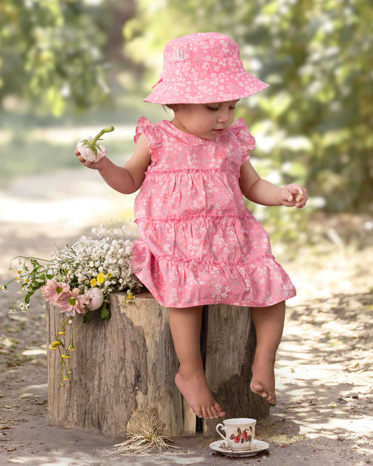 Child wearing Toshi Sunhat Acacia in Scarlet pink floral print.