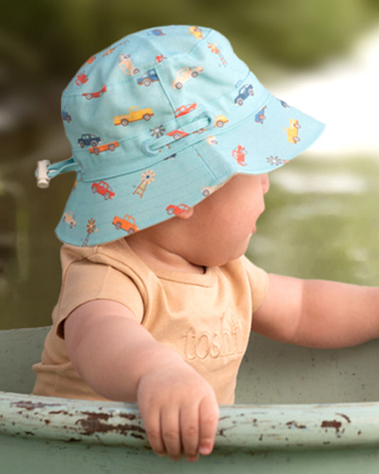 Child wearing Toshi Sunhat Ryder Utes Teal with adjustable chin strap.