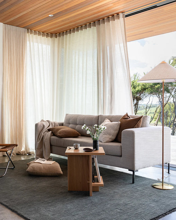 Modern living room with a gray sofa, wooden coffee table, and large windows. Sandringham forest green wool rug 160x230cm