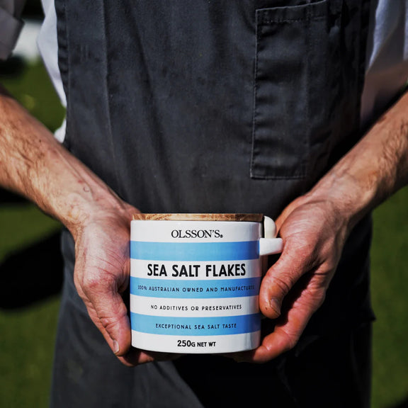 Person holding a container of Olsson's Sea Salt Flakes