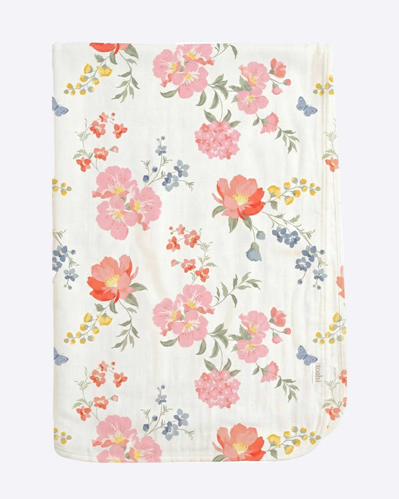 A folded muslin baby blanket with a delicate floral print on a white background, featuring pink, orange, and blue flowers with green leaves and yellow accents.