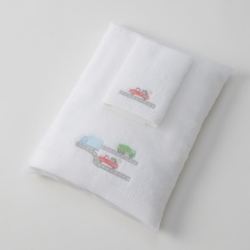White towels with embroidered designs of cars on a light gray background